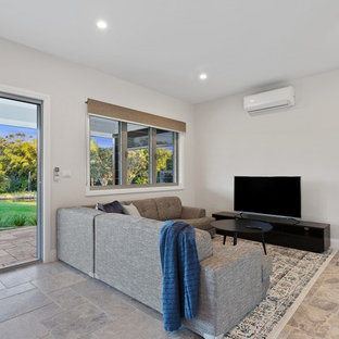 Idee per un piccolo soggiorno minimalista con pareti bianche, pavimento in travertino e TV autoportante