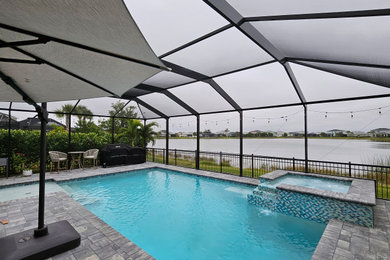 Mid-sized minimalist backyard concrete paver and custom-shaped lap pool photo in Miami