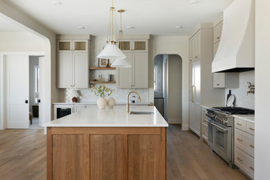 Kitchen - transitional l-shaped medium tone wood floor and brown floor kitchen idea in Minneapolis with an undermount sink, shaker cabinets, gray cabinets, white backsplash, stainless steel appliances, an island and white countertops