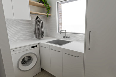 他の地域にある低価格の小さな北欧スタイルのおしゃれな洗濯室 (L型、白いキャビネット、クオーツストーンカウンター、白いキッチンカウンター) の写真