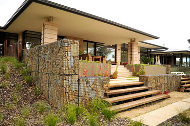 Inspiration for a large country backyard full sun garden in Melbourne with natural stone pavers.