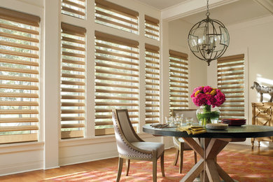 Example of a large classic light wood floor enclosed dining room design in Cleveland with white walls and no fireplace