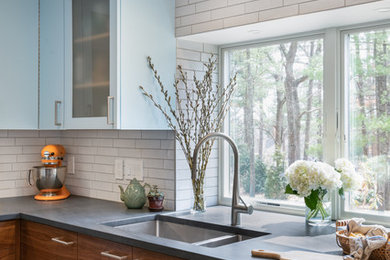 Inspiration for a mid-sized modern u-shaped porcelain tile and white floor open concept kitchen remodel in Boston with an undermount sink, flat-panel cabinets, dark wood cabinets, soapstone countertops, white backsplash, porcelain backsplash, stainless steel appliances, a peninsula and gray countertops