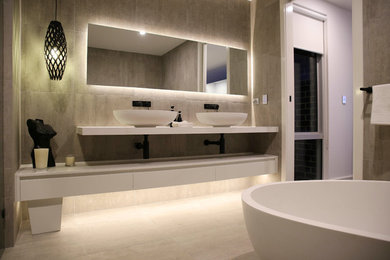 Inspiration for a large contemporary master bathroom in Sydney with a freestanding tub, gray tile, porcelain tile, grey walls, porcelain floors, a double shower, a vessel sink, engineered quartz benchtops, grey floor and an open shower.