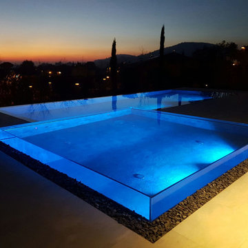 Piscina residenziale esterna con parete in vetro