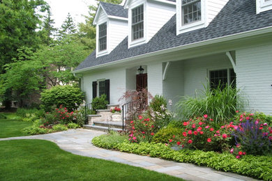 Photo of a traditional front yard stone flower bed in Chicago.