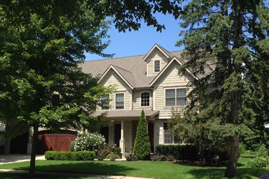 Example of a large classic beige two-story wood gable roof design in Chicago