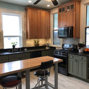 This is an example of a mid-sized arts and crafts l-shaped kitchen pantry in Louisville with an undermount sink, shaker cabinets, green cabinets, granite benchtops, beige splashback, ceramic splashback, stainless steel appliances, painted wood floors, with island and grey floor.