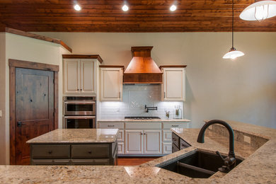Mid-sized arts and crafts u-shaped medium tone wood floor eat-in kitchen photo in Seattle with a drop-in sink, raised-panel cabinets, white cabinets, granite countertops, white backsplash, subway tile backsplash, stainless steel appliances and a peninsula