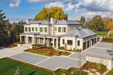 Modelo de fachada de casa beige moderna grande de dos plantas con revestimiento de piedra y tejado de metal