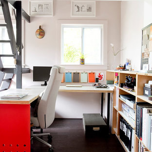 Idéer för att renovera ett litet funkis arbetsrum, med ett bibliotek, rosa väggar, mörkt trägolv och ett inbyggt skrivbord
