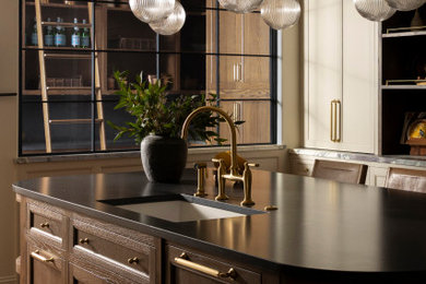 Large transitional kitchen photo in Dallas with shaker cabinets, white cabinets, marble countertops, black appliances and an island