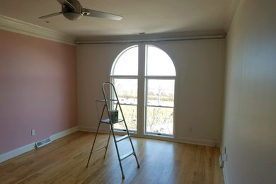 Modelo de habitación de invitados de tamaño medio sin chimenea con paredes rosas y suelo de madera en tonos medios