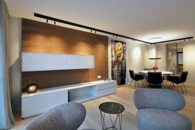 Modelo de salón abierto actual de tamaño medio con paredes blancas y suelo de madera en tonos medios