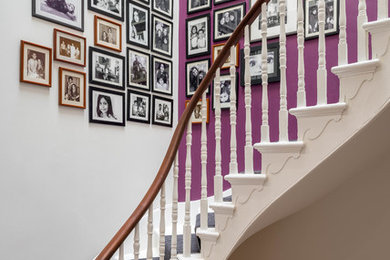 Inspiration for a large contemporary carpeted curved staircase in London with carpet risers.