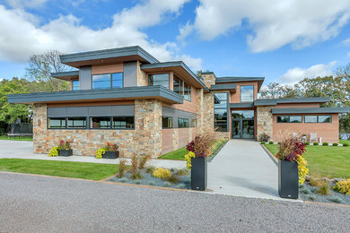 Large contemporary brown two-story wood exterior home idea in Minneapolis with a mixed material roof