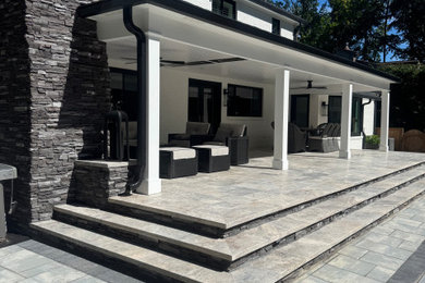 Patio - large coastal backyard patio idea in Other with a fireplace and a roof extension