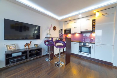 Example of a small minimalist l-shaped dark wood floor and brown floor open concept kitchen design in DC Metro with flat-panel cabinets, white cabinets, a peninsula, an undermount sink, wood countertops, glass sheet backsplash, stainless steel appliances and brown countertops