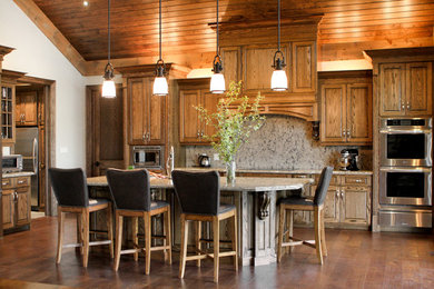 Mid-sized mountain style l-shaped medium tone wood floor open concept kitchen photo in Toronto with an undermount sink, raised-panel cabinets, medium tone wood cabinets, granite countertops, multicolored backsplash, stone slab backsplash, stainless steel appliances and an island