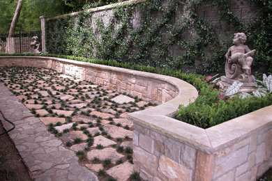 This is an example of a large mediterranean back patio with an outdoor kitchen, natural stone paving and a pergola.