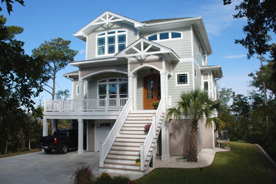 Example of a large beach style three-story concrete fiberboard exterior home design in Other