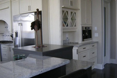 Eat-in kitchen - large contemporary l-shaped dark wood floor eat-in kitchen idea in Toronto with an island, recessed-panel cabinets, white cabinets, granite countertops, white backsplash, ceramic backsplash and stainless steel appliances