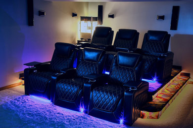 На фото: открытый домашний кинотеатр среднего размера в стиле неоклассика (современная классика) с ковровым покрытием, телевизором на стене и разноцветным полом с