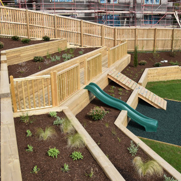 Extensive terraced raised beds with decking and play area.