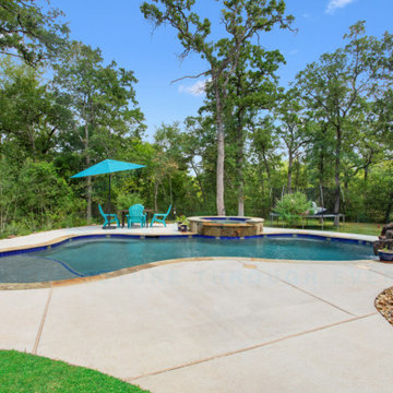 Freeform Pool with Spa, Rock Waterfall, Bubblers, and Flagstone Coping
