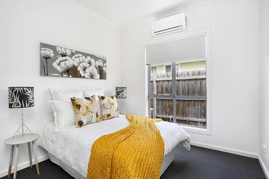 This is an example of a mid-sized contemporary guest bedroom in Melbourne with white walls and carpet.