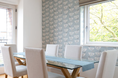 Inspiration for a medium sized modern kitchen/dining room in Manchester with blue walls, laminate floors, beige floors, wallpapered walls and a feature wall.