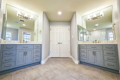 Cette image montre une salle de bain principale traditionnelle avec un placard à porte shaker, des portes de placard bleues, un carrelage multicolore, des carreaux de céramique, un mur beige, un sol en carrelage de céramique, un lavabo encastré, un plan de toilette en quartz modifié, un sol beige, une cabine de douche à porte battante, un plan de toilette blanc, des toilettes cachées, meuble double vasque et meuble-lavabo encastré.