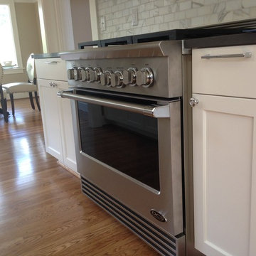 Custom cabinets, marble subway tile backsplash and 6-burner gas range