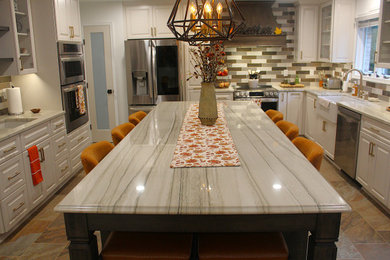 Inspiration for a large transitional u-shaped ceramic tile eat-in kitchen remodel in DC Metro with a farmhouse sink, shaker cabinets, white cabinets, granite countertops, ceramic backsplash, stainless steel appliances and an island