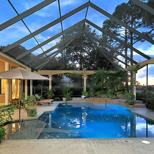 タンパのトロピカルスタイルのおしゃれな屋内プールの写真