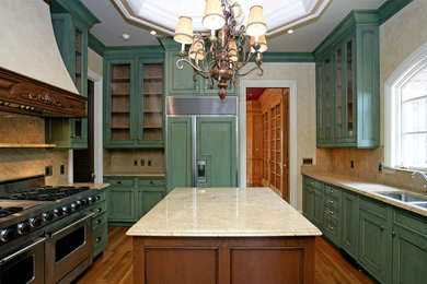 Photo of a large traditional u-shaped kitchen in St Louis with a double-bowl sink, glass-front cabinets, green cabinets, solid surface benchtops, stone slab splashback, panelled appliances, medium hardwood floors and with island.