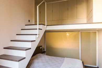 Idée de décoration pour une chambre parentale design de taille moyenne avec un mur gris et parquet foncé.