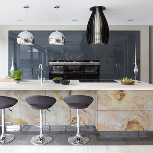 Large contemporary kitchen pantry remodeling - Inspiration for a large contemporary galley porcelain floor and gray floor kitchen pantry remodel in Hertfordshire with an undermount sink, flat-panel cabinets, distressed cabinets, quartzite countertops, black appliances, an island and white countertops