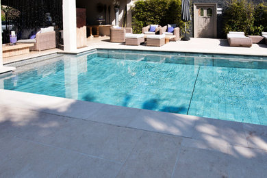 Cette image montre une piscine marine rectangle avec des pavés en pierre naturelle.