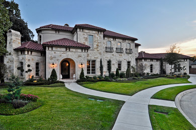 Example of a large classic gray two-story stone exterior home design in Dallas with a hip roof