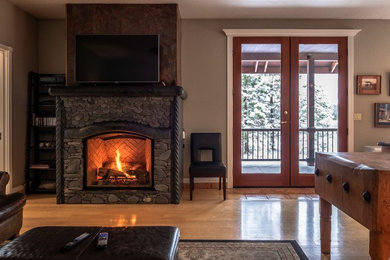 Small open concept brown floor living room photo in Other with a standard fireplace and a stone fireplace
