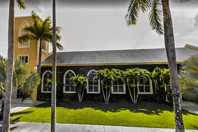 マイアミにある巨大なおしゃれな家の外観 (漆喰サイディング、黄色い外壁、下見板張り) の写真