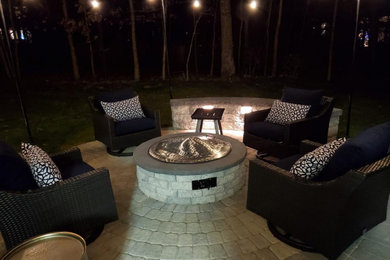 Mid-sized trendy concrete paver back porch idea in DC Metro with a fire pit