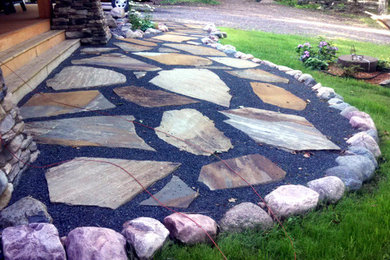 Inspiration for a rustic front yard stone garden path in Other.