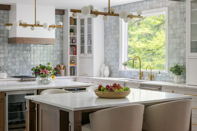 Inspiration for a large transitional l-shaped medium tone wood floor eat-in kitchen remodel in DC Metro with white cabinets, blue backsplash, two islands and white countertops