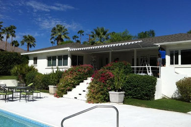 Example of a large patio design in Los Angeles with a roof extension