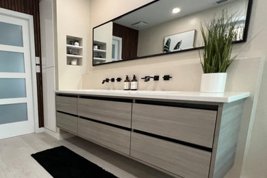 Inspiration for a mid-sized contemporary gray tile and porcelain tile porcelain tile, gray floor and single-sink bathroom remodel in Orlando with flat-panel cabinets, gray cabinets, beige walls, an undermount sink, quartz countertops, a hinged shower door and white countertops