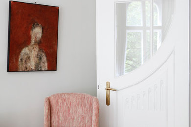 Großes Wohnzimmer mit grauer Wandfarbe, braunem Holzboden und braunem Boden in Berlin