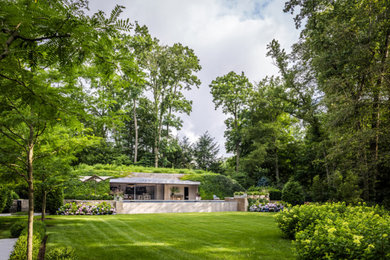 Example of a large trendy backyard stone and rectangular infinity pool design in New York