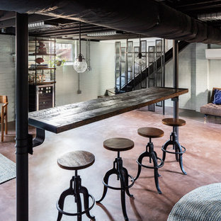 Imagen de sótano con ventanas industrial, grande, sin chimenea, con suelo de cemento y paredes blancas